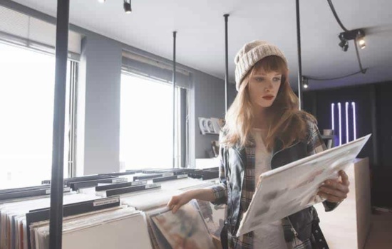 Record Store Manager holding a vinyl record in the record store