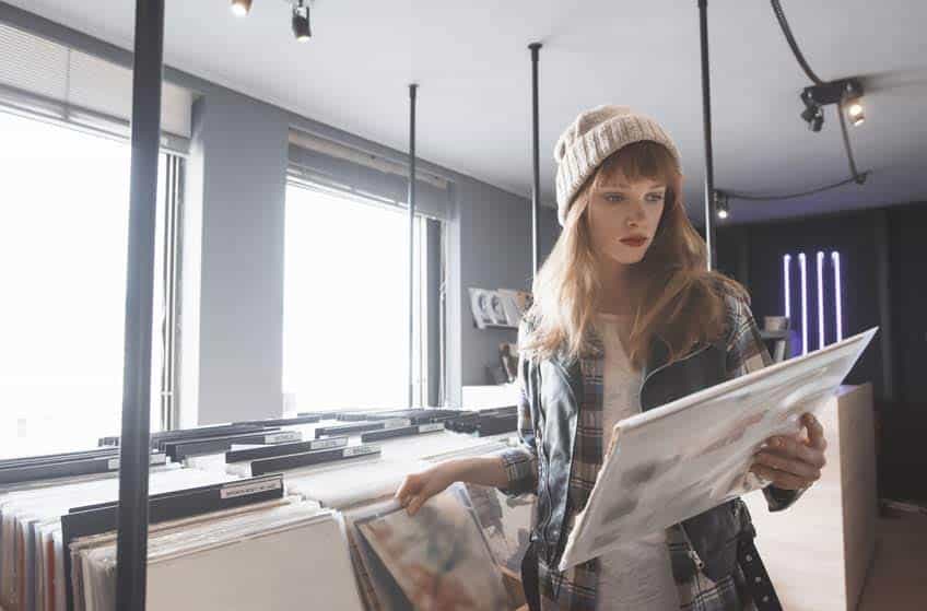 Record Store Manager holding a vinyl record in the record store