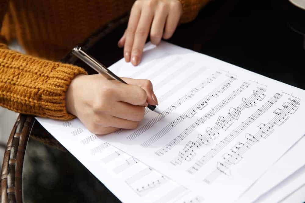 Arranger writing notes on sheet music