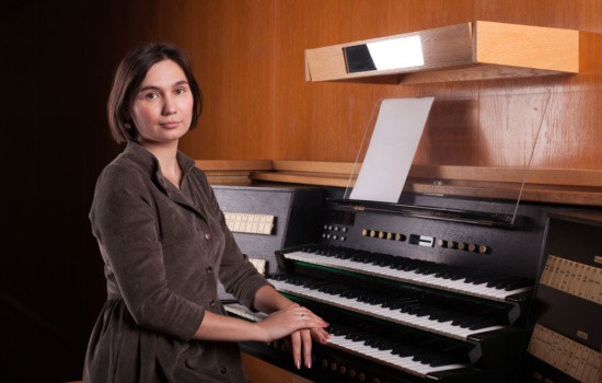 Church organist sitting with organ