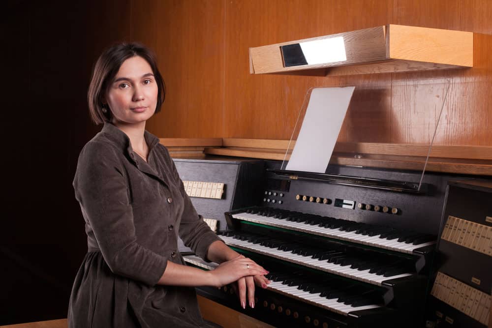 Church organist sitting with organ