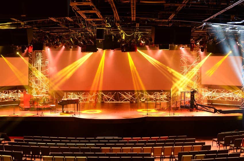 Empty concert stage with laser lights and piano