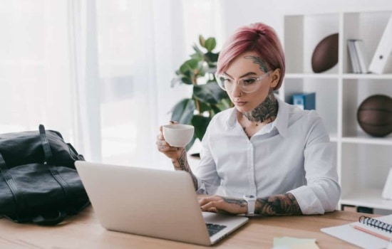 Director of Public Relations drinking tea in front of laptop