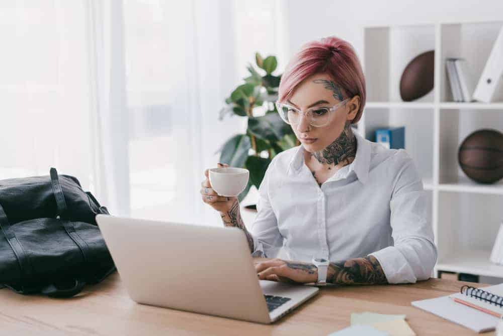 Director of Public Relations drinking tea in front of laptop