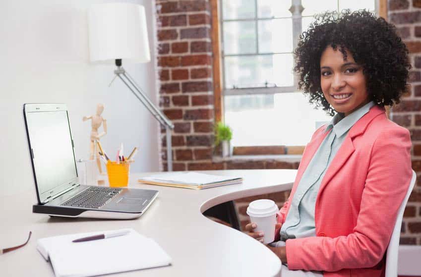 Stylish female Director of Publicity drinking coffee at her desk