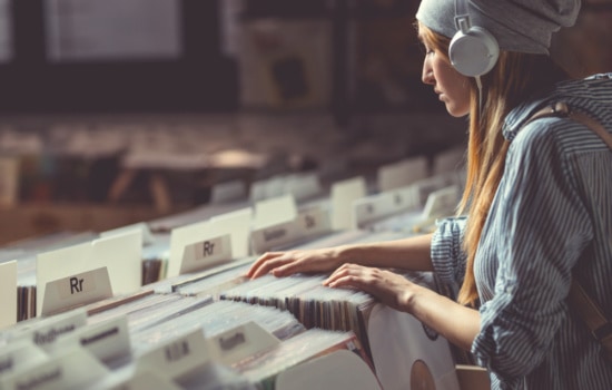 Young Field Merchandiser with headphones in music store