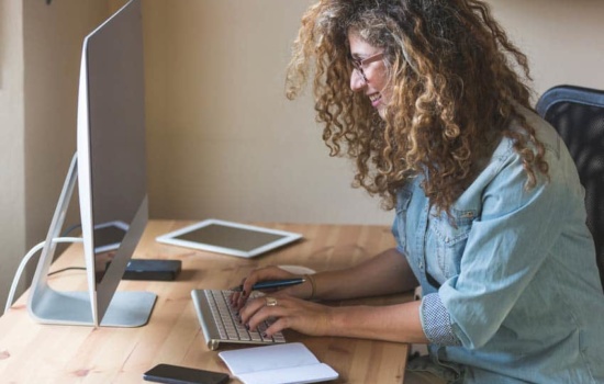 Music Journalist writing a story on her desktop computer
