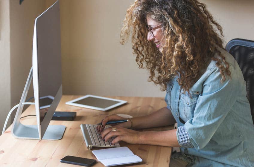 Music Journalist writing a story on her desktop computer