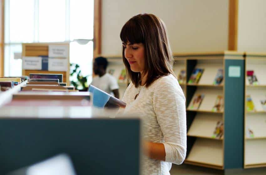 Music librarian placing music books on a shelf