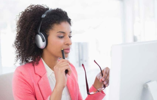 Music Publisher listening to music through headphones in her office