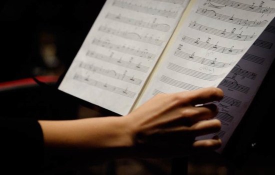 Orchestral Music Librarian turning pages of a score