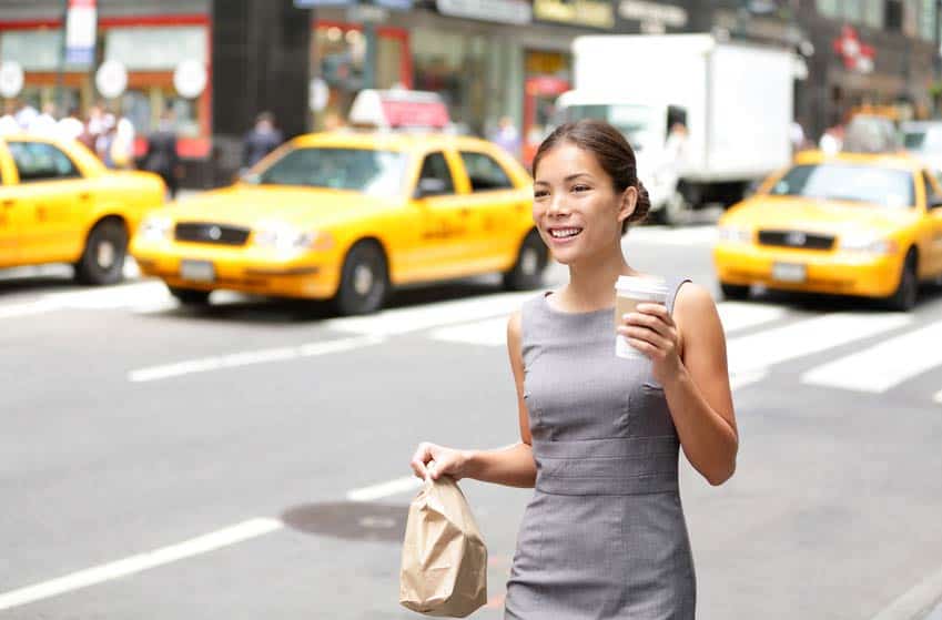 Asian female Personal Assistant to Recording Artist walking through New York City street with coffee and lunch