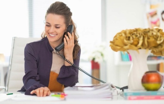 Music publicist on the phone with the media in her office