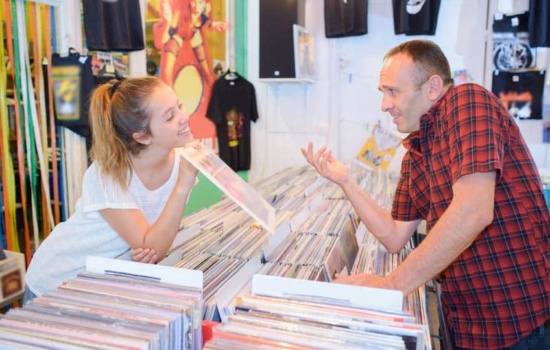 Rack Jobber showing new release to record store employee