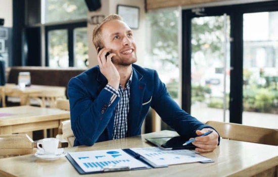 Regional Sales Manager on the phone and checking out sales figures at a cafe