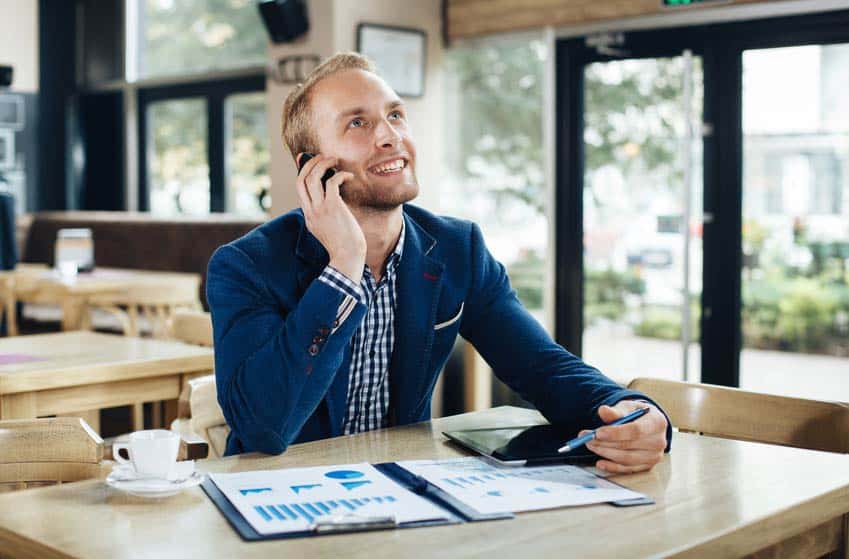 Regional Sales Manager on the phone and checking out sales figures at a cafe