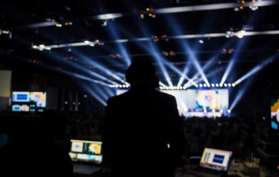 Video jockey controlling videos on stage at concert from the sound booth
