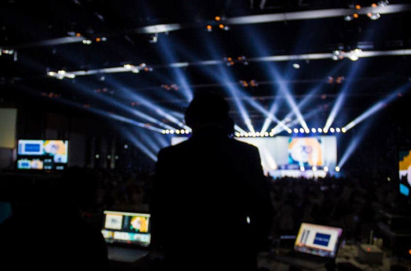 Video jockey controlling videos on stage at concert from the sound booth