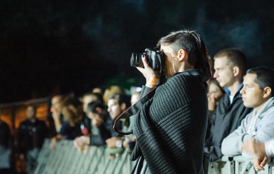 Female music photographer taking shots at a festival