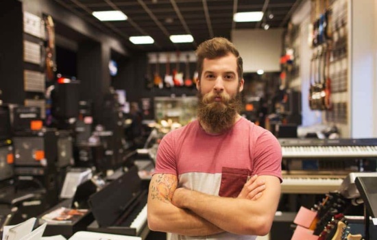 Bearded young man working at the musical instrument store