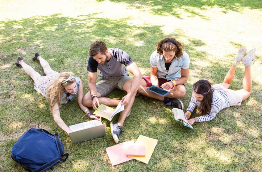 Music Business classmates sitting on campus lawn