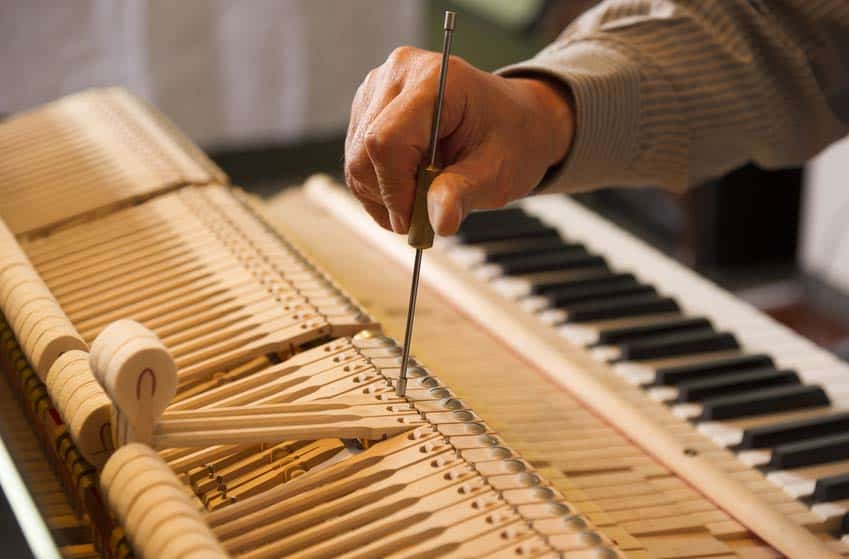Piano Tuner-Technician fixing the sound on a piano