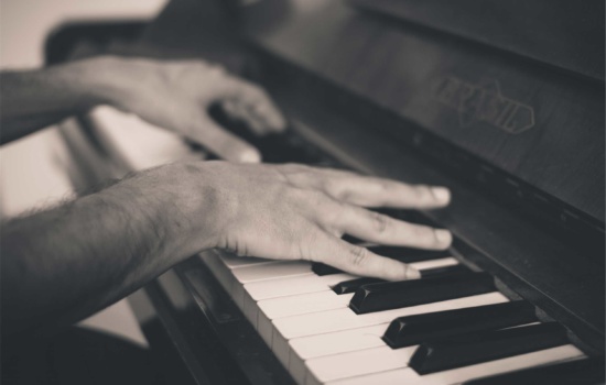 Closeup of hands playing a piano