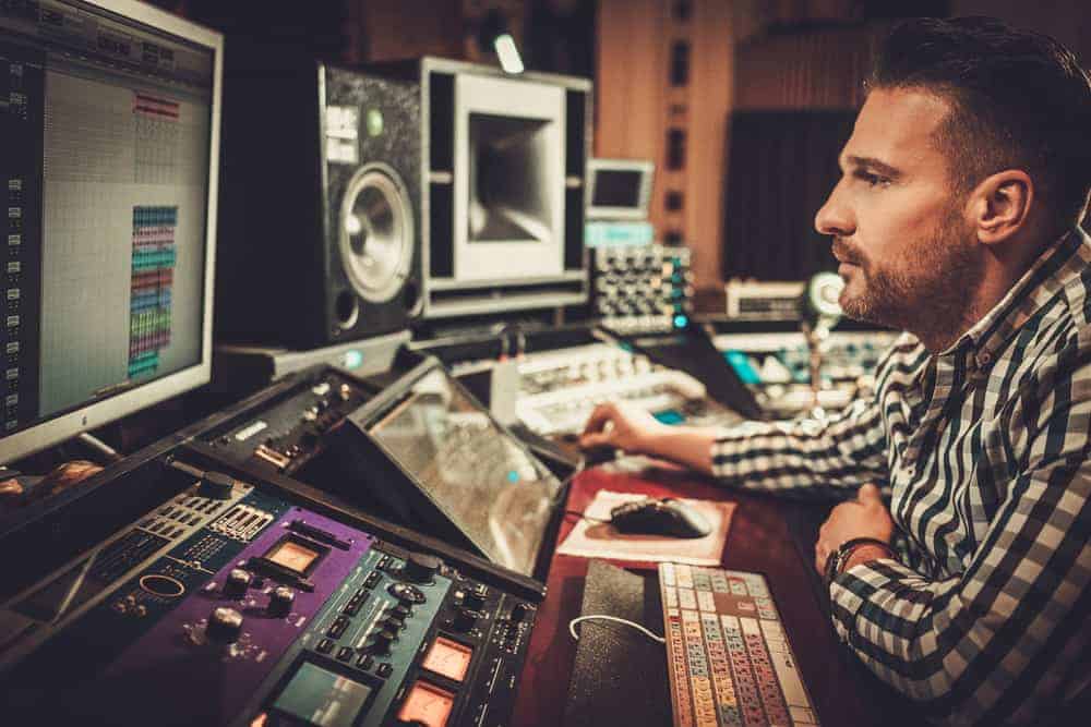 Assistant Engineer using a sound mixing desk in a recording studio