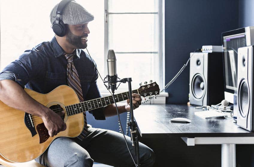 Jingle writer composing a guitar tune in his home recording studio