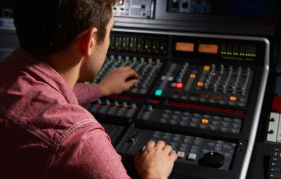 Mix engineer working at mixing desk in recording studio