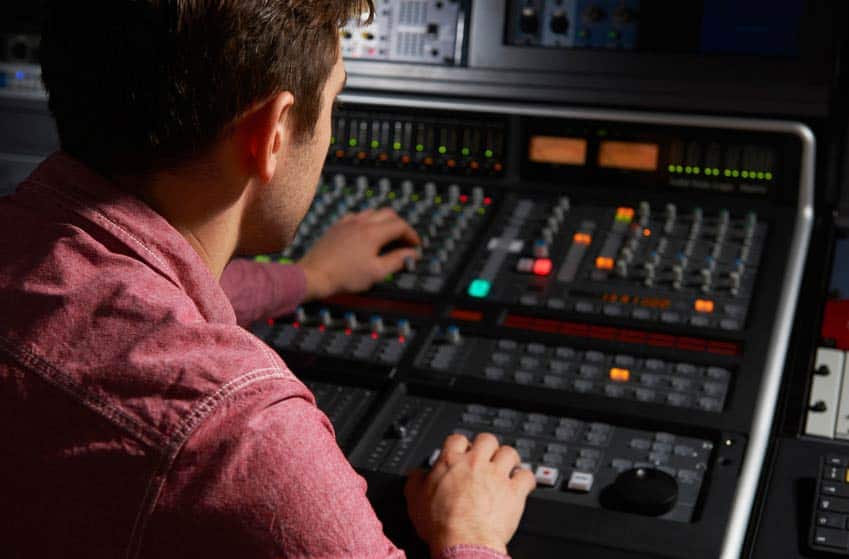 Mix engineer working at mixing desk in recording studio