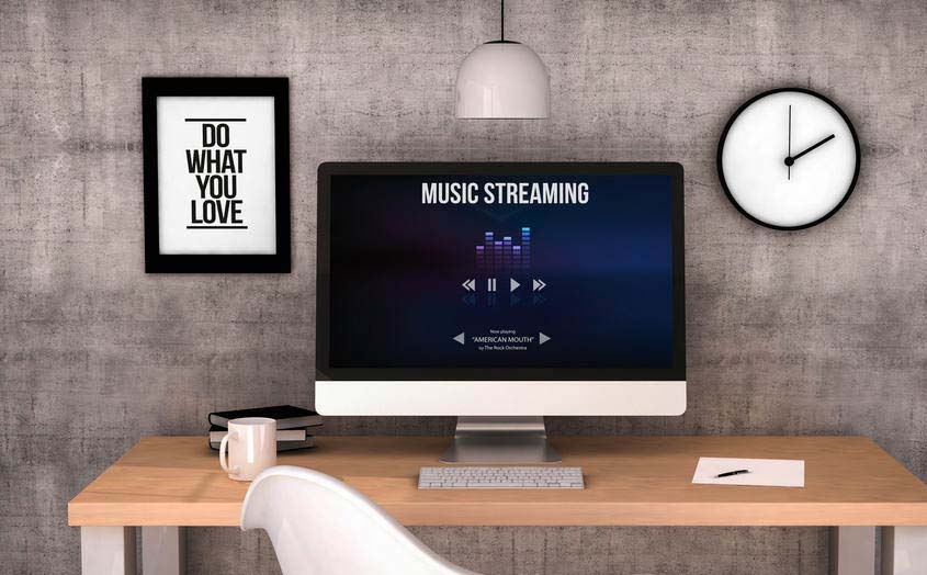 Music streaming website displayed on large desktop computer in modern workspace