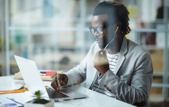 Talent Buyer listening to music on his earphones at the office