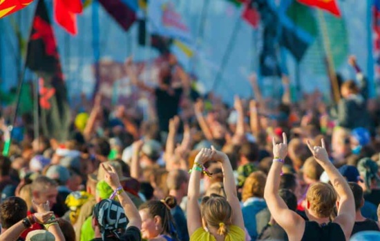 Large outdoor music festival crowd with multinational flags