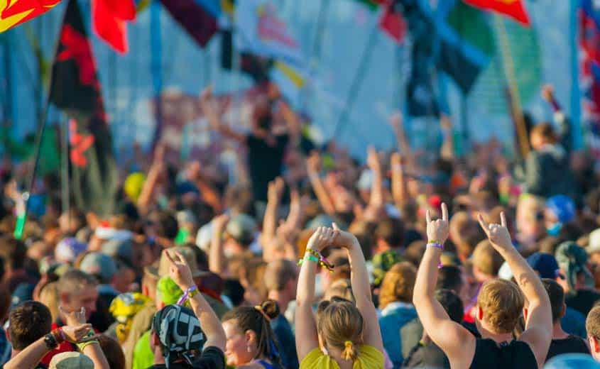 Large outdoor music festival crowd with multinational flags