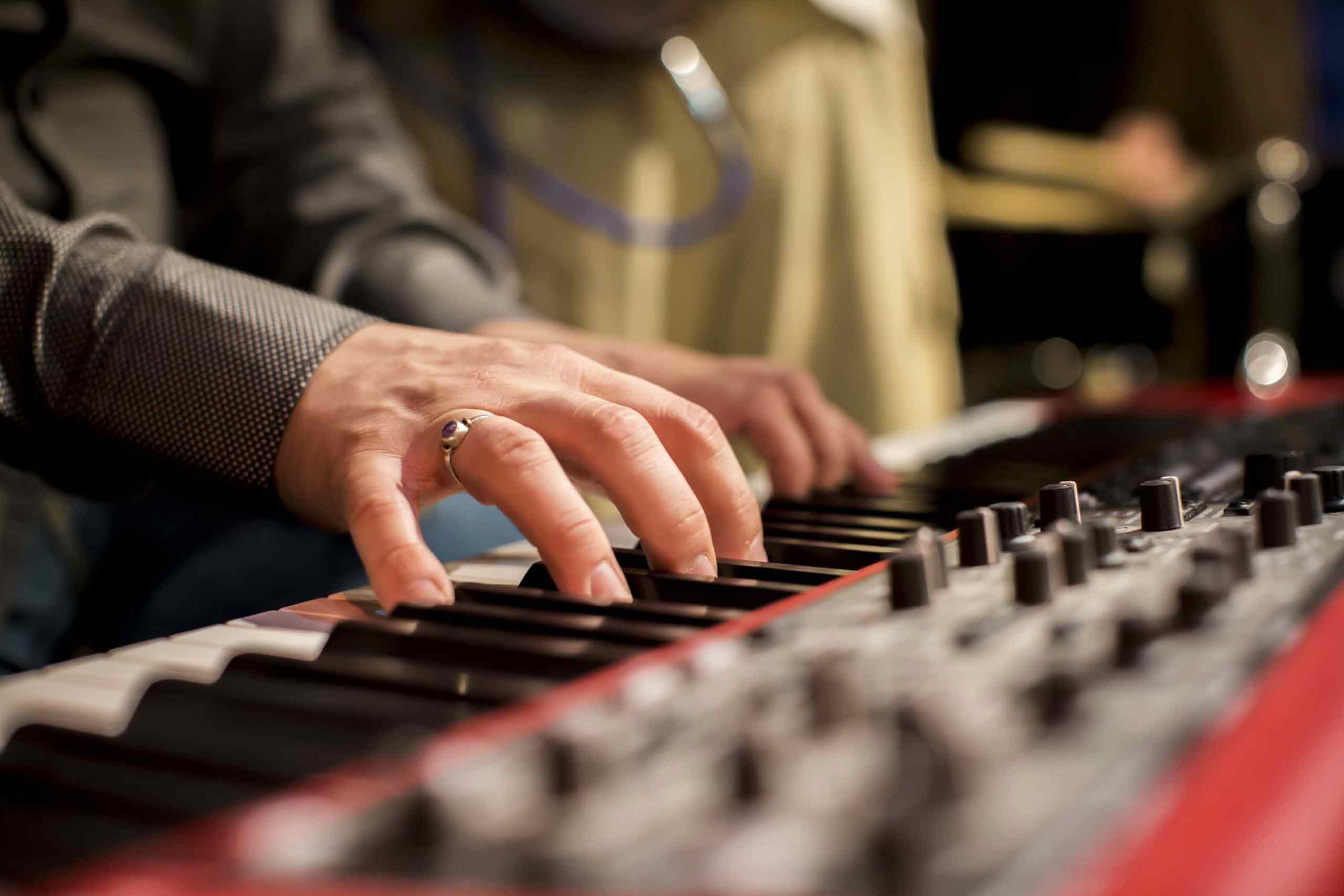 Closeup on a musician's hands playing a keyboard synth