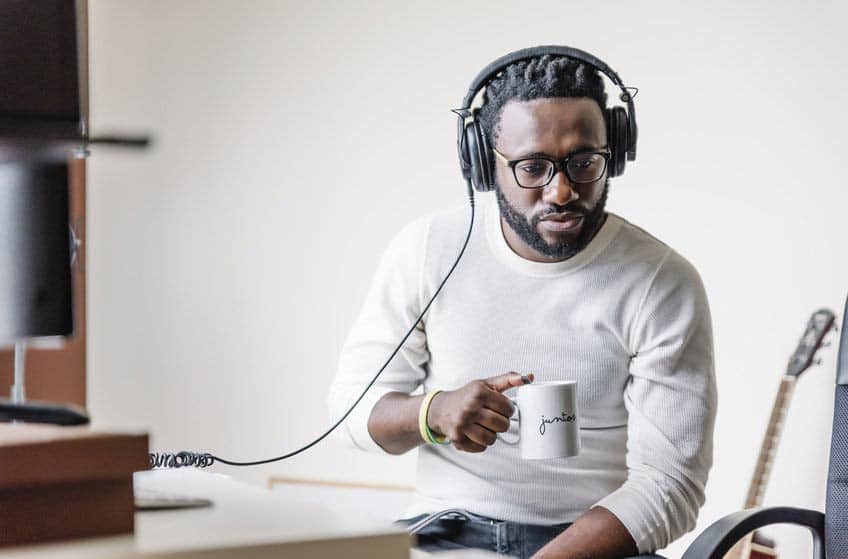 Pensive musician listening to songs via headphones