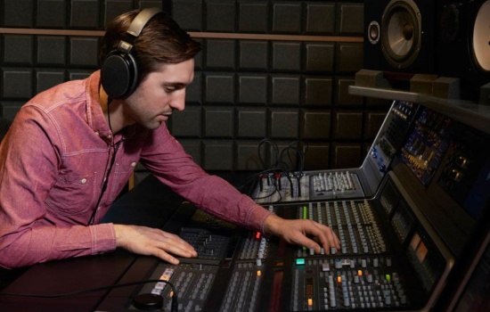 Mastering engineer using mixing console in recording studio