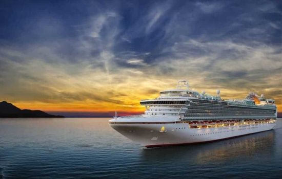 Luxury cruise ship sailing to port on sunset