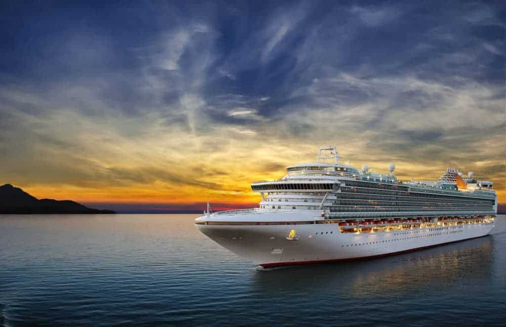 Luxury cruise ship sailing to port on sunset