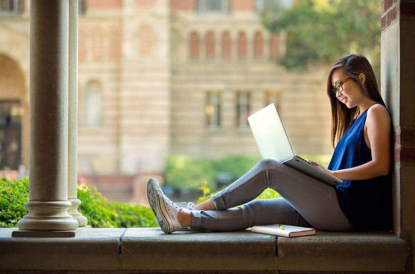 Music student on her laptop on college campus