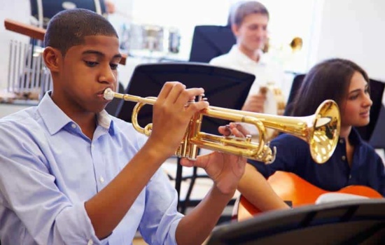Young trumpet player performing in high school band