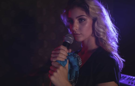 Female singer with microphone and scarfa
