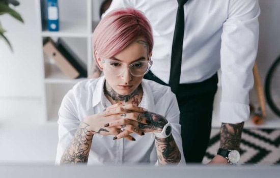 General manager of a record label concentrating with male coworker in background