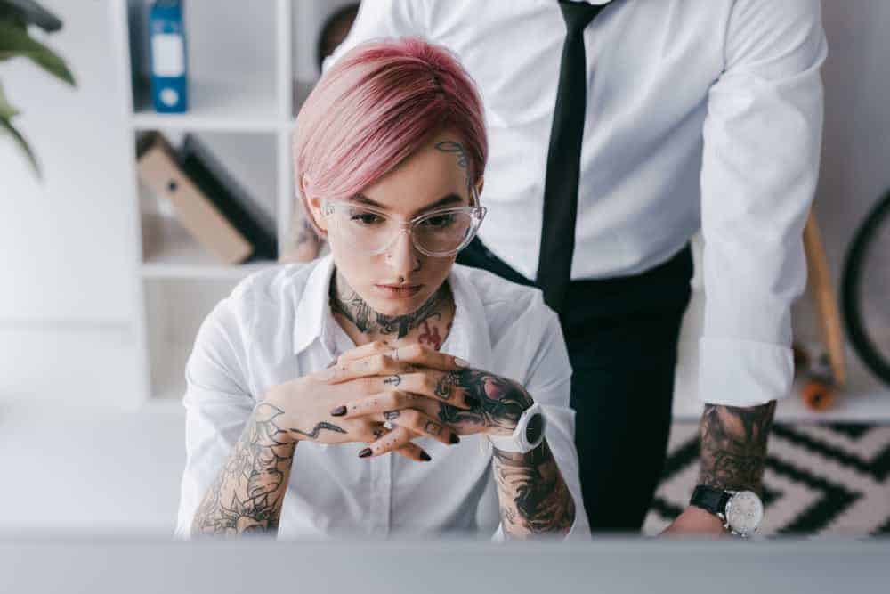 General manager of a record label concentrating with male coworker in background