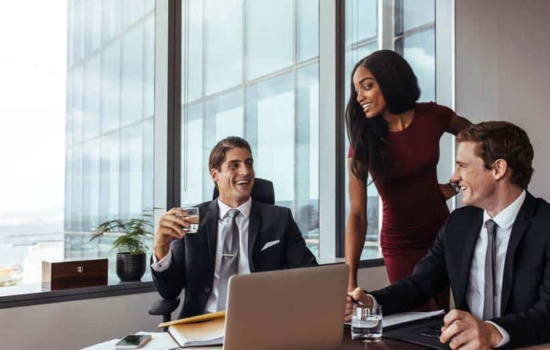 Two male music lawyers talking to female music lawyer in penthouse office