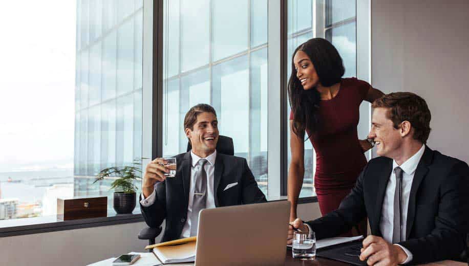 Two male music lawyers talking to female music lawyer in penthouse office