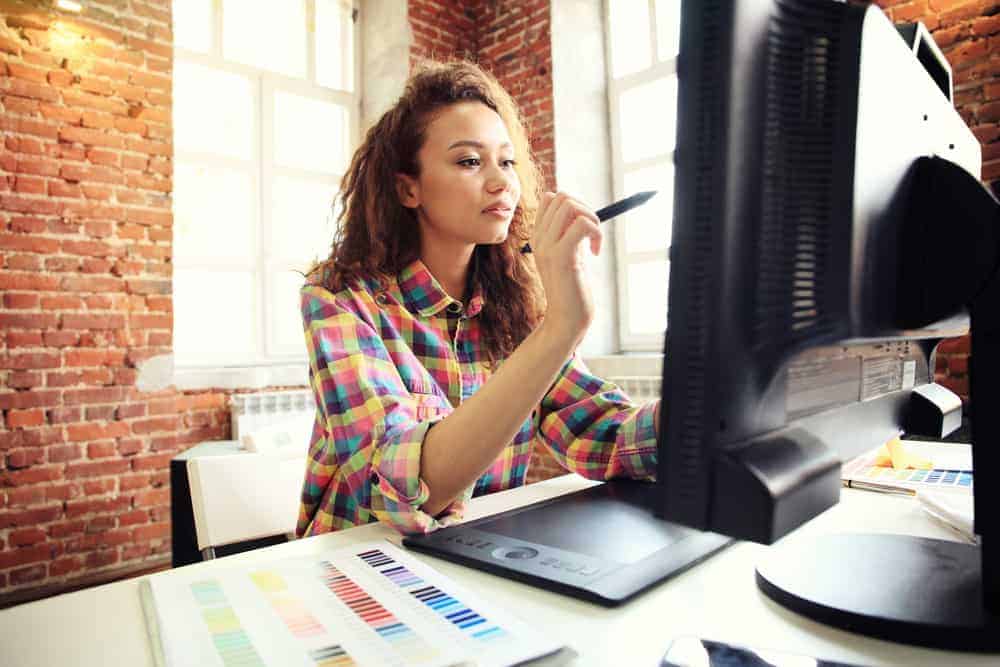 Poster artist using her computer and stylus to create a design