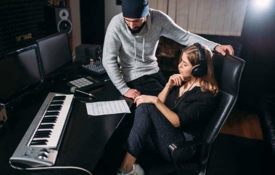 DIY music producers listening to music on headphones in home recording studio