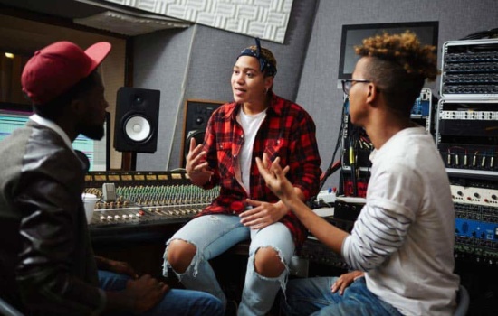 Artist manager with musicians in recording studio